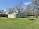 Vast backyard showing the detached garage, fire pit area, and spacious grassy area, offering a perfect blend of utility and leisure at 1210 W Grant St, Thorntown, IN 46071