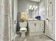Well-lit bathroom featuring marble floors, a white vanity, toilet, and a shower curtain at 1210 W Grant St, Thorntown, IN 46071