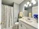 Updated bathroom with floral shower curtain, and a bright vanity at 1210 W Grant St, Thorntown, IN 46071