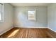 Inviting bedroom featuring hardwood floors, light gray walls, and windows overlooking the yard at 1210 W Grant St, Thorntown, IN 46071