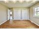 Bright bedroom with hardwood floors, a large window, and closet doors at 1210 W Grant St, Thorntown, IN 46071