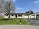 Charming one-story home featuring an attached garage, large front yard, and mature tree, a classic suburban retreat at 1210 W Grant St, Thorntown, IN 46071