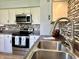 The kitchen sink is in the foreground, with stainless appliances and mosaic tile backsplash at 1210 W Grant St, Thorntown, IN 46071