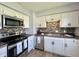 This kitchen features stainless steel appliances, white cabinets, and mosaic tile backsplash at 1210 W Grant St, Thorntown, IN 46071