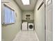 Cozy laundry room with washer, dryer, shelf, and window providing natural light at 1210 W Grant St, Thorntown, IN 46071