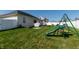 Spacious backyard featuring a playground set, patio with shade, and a well-maintained lawn at 122 Stamford Dr, Pittsboro, IN 46167