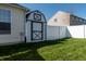 Backyard showcasing a shed with a white fence and lush green grass, perfect for outdoor activities at 122 Stamford Dr, Pittsboro, IN 46167
