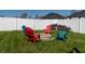 Cozy backyard fire pit area surrounded by colorful Adirondack chairs and a stack of firewood at 122 Stamford Dr, Pittsboro, IN 46167