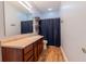 Well-lit bathroom featuring a single sink vanity with a wooden floor and a shower at 122 Stamford Dr, Pittsboro, IN 46167