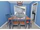 Dining room featuring a blue accent wall, matching chairs, and a view to back yard at 1229 Dallas Dr, Plainfield, IN 46168