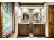 Double sink bathroom with two round mirrors and wood accents at 12613 Carrington Pl, Carmel, IN 46033