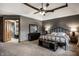 Bedroom boasts a ceiling fan, neutral carpet, and a view of the ensuite bathroom at 12613 Carrington Pl, Carmel, IN 46033
