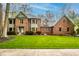 Charming two-story brick home featuring manicured landscaping and a lush green lawn at 12613 Carrington Pl, Carmel, IN 46033