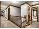 Hallway with wooden trim, carpet flooring, and staircase with wooden banister at 12613 Carrington Pl, Carmel, IN 46033