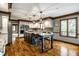 Spacious kitchen featuring a large island with marble countertops, stainless steel appliances, and hardwood flooring at 12613 Carrington Pl, Carmel, IN 46033