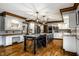 Open-concept kitchen with a large island, white cabinets, granite counters, stainless appliances, and wood floors at 12613 Carrington Pl, Carmel, IN 46033