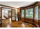 Sunlit living room boasts hardwood floors, wood trim, and a view of the staircase and front yard at 12613 Carrington Pl, Carmel, IN 46033