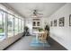 Bright sunroom featuring white paneling, tiled floors, ceiling fan, and a view to backyard and pool at 12613 Carrington Pl, Carmel, IN 46033