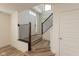 Bright foyer featuring wood-look floors, staircase with wood railing and white trim and door to the left at 13349 Minden Dr, Fishers, IN 46037