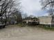 An exterior view of a mobile home with a small porch and a shed beside it surrounded by a spacious dirt yard at 154 Tippecanoe Dr, Noblesville, IN 46062