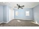 This bedroom features light blue walls, soft carpet, a ceiling fan, and windows for natural light at 1814 New St, Indianapolis, IN 46203