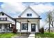 Charming home features a covered porch, black trim, and manicured landscaping at 1814 New St, Indianapolis, IN 46203