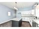 Contemporary kitchen boasts white cabinets, granite counters, stainless appliances, and dark island at 1814 New St, Indianapolis, IN 46203