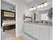 Bright bathroom with double vanity, white cabinetry, and doorway to a bedroom at 19405 Titus Dr, Westfield, IN 46074
