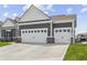 Spacious three-car garage with white doors and ample parking space on driveway at 19405 Titus Dr, Westfield, IN 46074