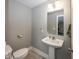 Cozy half bathroom showcasing a pedestal sink, toilet, and fresh neutral paint at 19702 Tomlinson Rd, Westfield, IN 46074