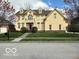 Inviting two-story yellow home featuring well-maintained landscaping and a charming balcony at 1984 Telfair St, Carmel, IN 46032