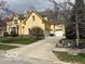 View of a two-story yellow home with lush lawn, side garage, and long driveway at 1984 Telfair St, Carmel, IN 46032