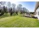 The backyard features a patio with seating, lush green grass, and mature trees at 20133 Willenhall Way, Westfield, IN 46074