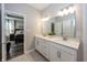 Bathroom with double sink vanity, ample countertop space, a large mirror, and access to the primary bedroom at 20133 Willenhall Way, Westfield, IN 46074