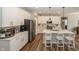 Bright kitchen boasts white cabinetry, stainless steel appliances, island with seating, and stylish pendant lighting at 20133 Willenhall Way, Westfield, IN 46074