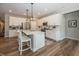 Kitchen features include white cabinets, stainless steel appliances, quartz counters, an island with seating and pendant lights at 20133 Willenhall Way, Westfield, IN 46074