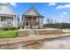 Newly renovated gray home featuring a modern porch with stained wood, contemporary black front door, and a block-wall landscape border at 2118 Lexington Ave, Indianapolis, IN 46203