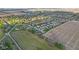 An aerial view showcasing a residential neighborhood bordering agricultural fields and a distant cityscape at 2511 Countryside Westview Dr, Shelbyville, IN 46176