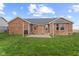 Exterior of a red brick house with a well-maintained backyard featuring a stone patio and green lawn at 2511 Countryside Westview Dr, Shelbyville, IN 46176