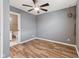 This bedroom boasts wood floors, a modern ceiling fan, neutral walls, and a convenient door to an ensuite bathroom at 2511 Countryside Westview Dr, Shelbyville, IN 46176