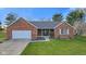 Charming red brick home with a well-manicured lawn, a two-car garage, and a welcoming front entrance at 2511 Countryside Westview Dr, Shelbyville, IN 46176