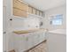 Bright laundry room with wooden countertop, white cabinets, storage baskets, and natural light at 2511 Countryside Westview Dr, Shelbyville, IN 46176