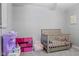 Bright bedroom features a crib, toy kitchen, small chair, and a light gray carpet at 2936 W Calimanco Ln, Monrovia, IN 46157