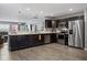 Modern kitchen featuring stainless steel appliances, dark cabinetry, marble counters, open to the living room at 2936 W Calimanco Ln, Monrovia, IN 46157