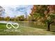 Scenic pond surrounded by green lawn and a variety of colorful mature trees, offering a serene view at 2936 W Calimanco Ln, Monrovia, IN 46157