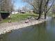 Scenic view of the waterfront with stone shoreline, picnic tables, and lush green grass nearby at 3311 Stella St, Greenwood, IN 46143
