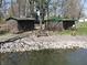 Waterfront with wooded landscape, rocky shoreline and outbuildings in the background at 3311 Stella St, Greenwood, IN 46143