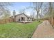 Well-maintained backyard featuring a spacious deck, lush green lawn, gravel pathway, and privacy fence at 334 Stonehedge Dr, Carmel, IN 46032
