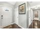 Hallway featuring pristine white doors, stylish hardware, and gleaming hardwood floors leading to various rooms at 334 Stonehedge Dr, Carmel, IN 46032