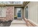 Close-up of the front door, showcasing its decorative wreath and welcoming entrance with brick and siding details at 334 Stonehedge Dr, Carmel, IN 46032